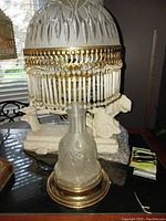 Full view of the vintage crystal lamp showing the cut glass dome shade, frosted base, and brass platform.