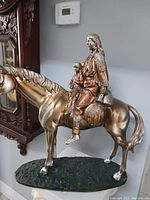 Full side view of the statue showing woman and child seated on the horse, highlighting size and composition.