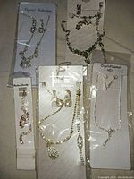 Overview of multiple jewelry pieces on display including necklaces, bracelets, and earrings, showing brand packaging and presentation.