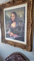 Frontal view of ornate gold-painted wooden frame containing Mona Lisa print with white border