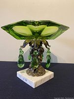 Front view of the green glass ashtray with bronze cherub and marble base showing dangle crystals