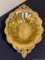 Photo of the large oval hammered brass serving dish from top view showing scalloped edge and decorative handles.