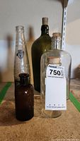 Photo showing five vintage glass bottles grouped together with various shapes and cork stoppers