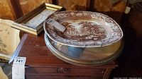 Photo showing the platter, round and rectangular framed wall art on wooden furniture.