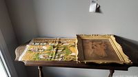 Table top with textile 'Cottages in Ireland' wall hanging and framed print of dancers side by side