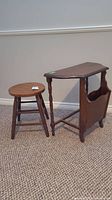 Photo of both vintage side table with magazine rack and wood stool placed together on carpeted floor