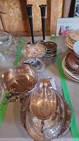 Photo showing silver plated serving dishes including pierced bowl, oval dish, tiered dish, and coaster stack with black candle sticks in background