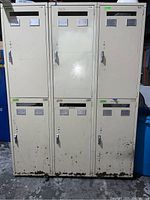 Front view of six half-height metal lockers showing rust and wear on the lower edges and front doors.