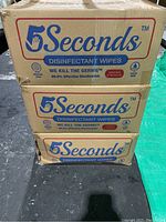 Photo showing three stacked cardboard boxes labeled 5 Seconds Disinfectant Wipes, highlighting packaging and branding.