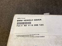 Label on the box showing BMW Group branding, product name 'BMW Vehicle Cover' and part number 82 11 0 399 144.