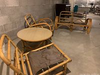 Photo of the entire vintage rattan living room set including armchair, sofa, and round coffee table.