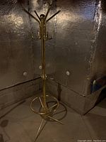 Full view of vintage brass hall tree coat rack showing all hooks and umbrella stand base.