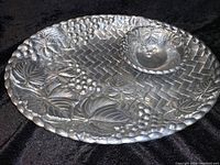 Oval Lenox pewter serving platter and coordinating footed bowl showing grape and leaf embossed design and basket weave background.