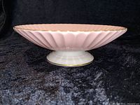 Side profile of Lenox Fluted pink candy dish showing fluted design, white base, and gold rim.