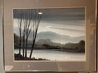 Front view of the framed original painting showing a waterside landscape with bare trees and misty environment under glass.