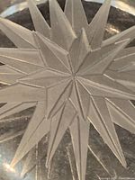 Close-up detail of the etched star pattern in the center of the glass item.