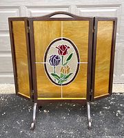 Front view of the three-panel folding fireplace screen with stained glass floral design.