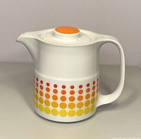 Side view of the vintage Noritake Primadura teapot showing the handle, spout, and polka dot pattern in yellow, orange, and red on white porcelain.