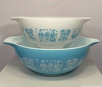 Two bowls stacked, showing white smaller bowl on top with turquoise Butterprint and larger turquoise bowl underneath with white Butterprint.