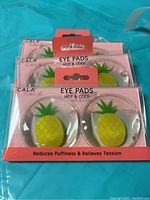 Photo showing three unopened packs of Cala Hot & Cold Gel Eye Pads with pineapple design, packaged for reducing puffiness and relieving tension.
