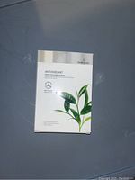 Photo of Beautigen antioxidant face masks box featuring green tea essence and a graphic of green tea leaves