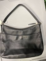 Full front view of the black leather Kate Spade purse with single shoulder strap