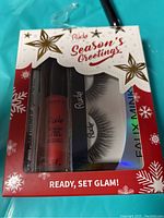 Photo of closed Rude Cosmetics Lash and Lip Kit in festive holiday packaging showing contents through blister window.