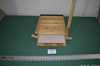 Front view of the cedar triple chamber bat house showing the distinct three chambers and bottom mounting ledge with ruler for size reference.