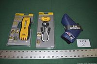 Photo showing the unopened Sperry Instruments CS61200P circuit breaker finder transmitter and receiver in original packaging alongside a blue New England Patriots golf club blade putter cover on green background with measuring ruler at bottom.