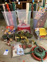 Photo showing three plastic storage boxes filled with various rolls of wrapping paper, two clear plastic boxes with bows, tissue paper, gift bags, and assorted holiday accessories.