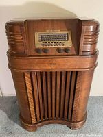 Front view of Philco console radio showing curved wood cabinet and grille