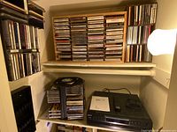 Overview of the CD changer player, remote, manuals, and multiple CD storage holders filled with CDs.