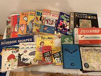 Photo taken showing the full assortment of vintage children's educational and recreational books and games neatly arranged on a surface.