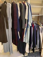 Photo showing a rack of women's dresses and casual wear items hung on hangers including brown and blue dresses and knitwear