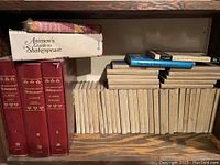 Wide view of shelves showing entire beige cloth Yale Shakespeare set, three red Annotated Shakespeare volumes, boxed Asimov's Guide to Shakespeare, and other books on top of set
