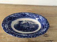 Full view of antique Staffordshire transferware bowl showing blue and white scenic design with castle and landscape motif and ornate border.