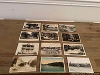Photo showing 12 vintage Muskoka postcards spread out on wooden floor, includes various cottages, lodges, and waterfront scenes in black and white and color.