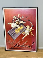 Photo of the framed French print showing a vintage advertisement for Suchard Milka chocolate with children on a red background.