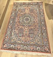 Full view of rectangular silk rug on floor