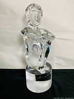 Front view of clear glass bust sculpture on cylindrical base