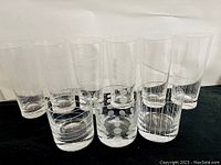 Front view of eight Mikasa glasses showing two sizes and three etched patterns: large polka dots, vertical stripes, and horizontal stripes.