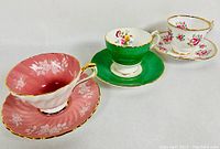Three bone china cup and saucer sets displayed angled, front view