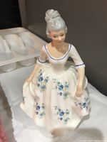 Front view of the Royal Doulton porcelain figurine showing detailed blue floral patterns on the white dress and the elegant hairstyle.