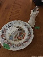 Image of the Royal Doulton collector plate featuring a winter scene from the Brambly Hedge Collection with floral decorating rim.