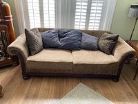 Full view of vintage Bernhardt mocha sofa with three seat cushions and five throw pillows in a living room.