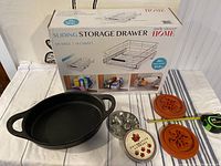Photo showing black All-Clad baking dish, Seville Classics sliding storage drawer box, metal tin of decorative maple leaf pie cutters, two terracotta-colored round pie crust cutters, measuring tape