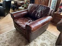 Restoration Hardware leather recliner coffee brown color, angled view showing seat and back cushions with creases and wear.