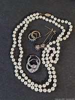 Overview photo showing a full cultured pearl necklace and three pairs of assorted earrings including topaz hoops, cubic zirconia threaders, and silver-toned hoops.