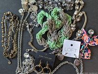 Photo showing a variety of Ann Taylor and Loft branded costume jewelry items including necklaces with green seed beads and silver chains, and earrings on original cards.