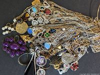 Full view of multiple signed Avon necklaces showing variety of pendants and chain styles.